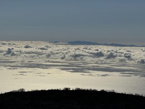 Above the clouds, with the island of Gran Canaria in the distance.