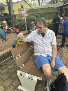 Our friend Mike Houser with a macaw that likes his head scratched.