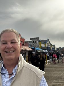 Marshall smiling on a cloudy day in California route 66 sign